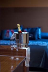 due bicchieri di vino su un tavolo con una bottiglia in un secchio di Motel Los Abedules a Oviedo
