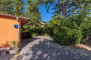 un vialetto con un'auto parcheggiata accanto a un edificio di Apartment Samblich Atelier a Krk