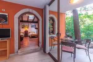 una porta aperta su un patio con tavolo e sedie di Apartment Samblich Atelier a Krk