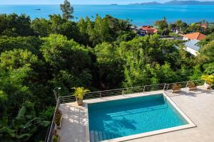 an outdoor swimming pool with a view of the ocean at The Penthouses, Bangpor Seaview Luxury Apartment in Koh Samui 