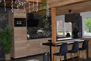 a kitchen with a bar with two chairs and a table at A Casita del Pedro in Rimbachzell +19 photos