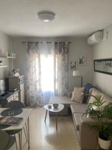 un salon avec un canapé et une table dans l'établissement Apartamento en Casco Histórico, à Cordoue