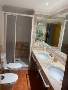 une salle de bain avec deux lavabos et un WC et un miroir dans l'établissement Apartamento en Casco Histórico, à Cordoue 12 autres photos