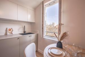 a kitchen with a table and a window at Villa Victor Hugo by Odomo in Avignon +59 photos