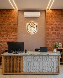 a reception desk with a computer on a brick wall at Yashvrinda in Mandor