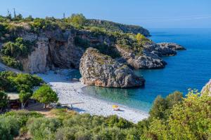 a beach with rocks in the water next to the ocean at Villa Eleni - Private Pool Retreat near Kardamili in Proástion