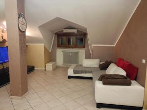 a room with two beds and a couch and a clock at Ale Sweet Home in Piossasco