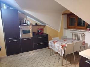 a kitchen with a table and a kitchen with a stove at Ale Sweet Home in Piossasco
