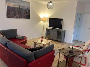 a living room with a red couch and a flat screen tv at Ferienwohnung Südstraße in Eschede