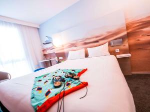 a hotel room with a bed with headphones on it at ibis Styles Toulon Centre Port in Toulon