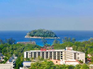 an island in the ocean next to a building at Ibis Phuket Kata in Kata Beach
