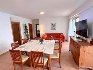 a dining room with a table and chairs and a television at Terrace apartment with panoramic seaview in Ubli