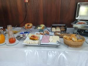 a table with a buffet of food on it at Hotel Floresta in Poços de Caldas