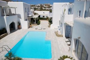a villa with a swimming pool and white buildings at Elysia House in Ornos
