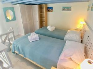 a bedroom with two beds with towels on them at Elysia House in Ornos