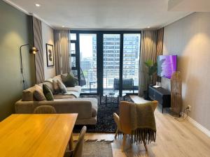 una sala de estar con un sofá y una mesa en Urban Elephant 16 On Bree, en Ciudad del Cabo