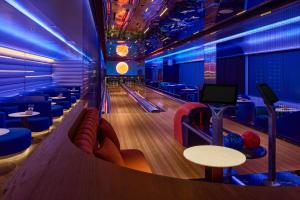 a bowling alley with lanes and tables and blue lights at InterContinental Taichung by IHG in Taichung