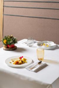 biały stół z talerzami z jedzeniem na nim w obiekcie Grand Hotel Courmayeur Mont Blanc, by R Collection Hotels w mieście Courmayeur
