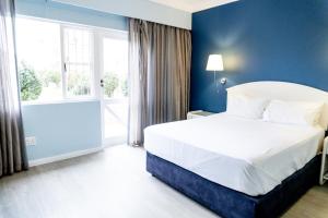 Un dormitorio con una cama grande y una pared azul. en Saldanha Bay Hotel, en Saldanha