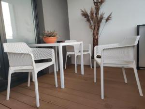 ワンツトにあるApartament Rutkiewiczの白いダイニングテーブル(白い椅子、テーブル付) +5枚の写真