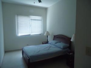 ein weißes Schlafzimmer mit einem Bett und einem Fenster in der Unterkunft Balcones -Torre IV in Playa Blanca