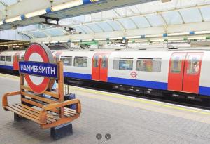 a train station with a bench in front of a train at Artsy & bright Hammersmith London 1b1b, up to 4 people in London