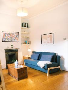 a living room with a blue couch and a fireplace at Artsy & bright Hammersmith London 1b1b, up to 4 people in London