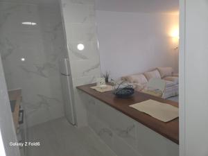 un bagno con lavandino, doccia e divano di Los Gigantes apartment 113, 1 bedroom ad Acantilado de los Gigantes