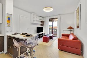 a living room with a red couch and a kitchen at Art&Comfort Apartment - 2 passi dalla Stazione in Paderno Dugnano