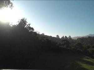 een heuvel met bomen en de zon in de lucht bij Horseshoe Valley in Wilderness +2 foto's