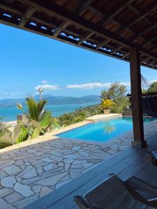 a view of the pool from the deck of a villa at Casa em Paraty, piscina com vista para o mar in Paraty