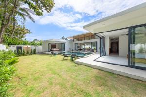 a backyard with a pool and a house at Villa Gabriela Garden view - Included Airport pick up in Nathon Bay