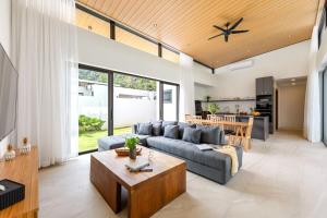 a living room with a couch and a table at Villa Gabriela Garden view - Included Airport pick up in Nathon Bay