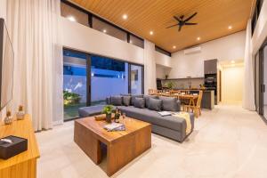 a living room with a couch and a table at Villa Gabriela Garden view - Included Airport pick up in Nathon Bay