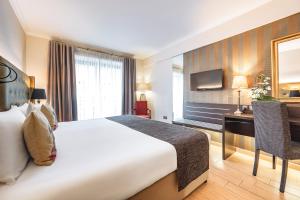 a hotel room with a bed and a desk at AX The Victoria Hotel in Sliema
