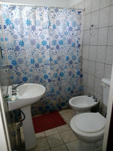 Un baño con lavabo, inodoro y cortina de ducha. en El Ñandubay, en San José