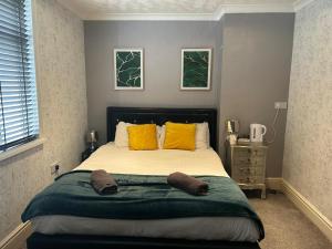 a bedroom with a large bed with yellow pillows at The Chorlton by Cherish Lewis Hotel in Blackpool