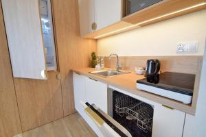 a small kitchen with a sink and a microwave at Bel mare aqua 2 Aquapark in Międzyzdroje