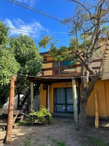 una casa con un árbol delante en La Casa del Caminante, en Aguas Dulces