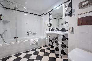 a bathroom with a sink and a tub and a toilet at AX The Victoria Hotel in Sliema