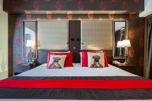 a bedroom with a bed with two dogs on the pillows at AX The Victoria Hotel in Sliema