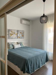 Un dormitorio con una cama con una manta azul. en Apartamento JALAMA 1C, en Moraleja