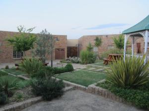 a courtyard with a garden with grass and plants at Vreugde Gasteplaas in Warden