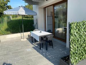 an umbrella and a table and chairs on a patio at Casa Vacanza da Zia Piera in Pettenasco