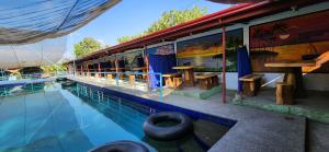 a house with a swimming pool next to a building at Nawal Raymundo Resort in Santa Cruz