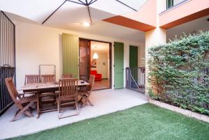 a patio with a wooden table and chairs at FARE BnB- la chicca di Emilio in Cavriago