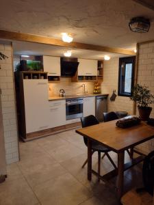 a kitchen with a wooden table and a dining room at Holiday apartement Sentjur in Šentjur +10 photos