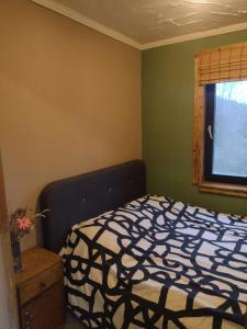 a bedroom with a black and white bed and a window at Holiday apartement Sentjur in Šentjur