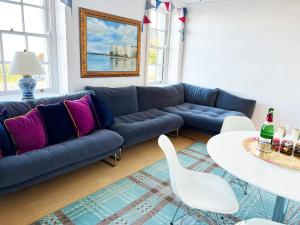 a living room with a blue couch and a table at Broadstairs Beach Holiday Apartments, self-catering seafront stays at Kingsgate Bay, with parking space in Broadstairs