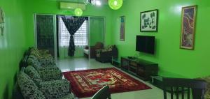 a green living room with a couch and a tv at Homestay Shah Alam in Shah Alam